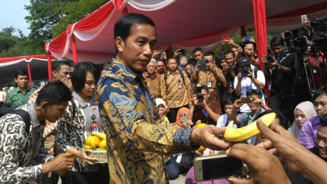 Presiden Joko Widodo bagikan pisang pada awak media di Fruit Indonesia 2016.