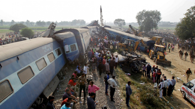 Petugas penyelamat mencari korban yang masih hidup di lokasi anjloknya kereta di Pukhrayan, selatan Kanpur city, India, 20 November 2016.