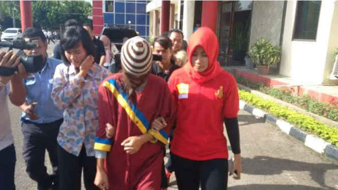 Siska Nopriana, ibu rumah tangga pelaku pembunuhan anak saat digiring kepolisian untuk menjalani pemeriksaan, Selasa (22/11/2016)
