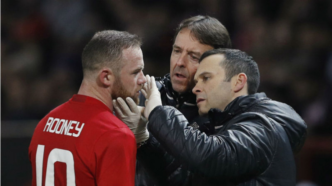 Kapten Manchester United, Wayne Rooney, saat mendapatkan perawatan.