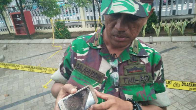 Seorang prajurit TNI menunjukkan foto lokasi penemuan granat nanas yang masih aktif di halaman kantor PT Pertamina Region VII Sulawesi, Makassar, pada Senin 5 Desember 2016.