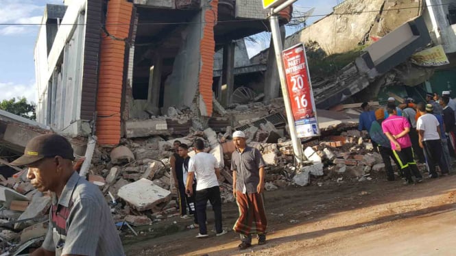 Warga mengamati bangunan yang rusak akibat gempa di Aceh, Rabu, 7 Desember 2016.