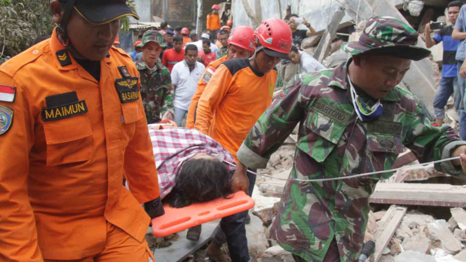 Petugas mengevakuasi jenazah korban gempa Aceh.