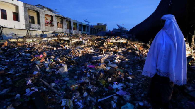 Warga menyaksikan puing bangunan pasar Meuredu yang rubuh akibat gempa di Pidie Jaya, Aceh, Kamis (8/12/2016). 