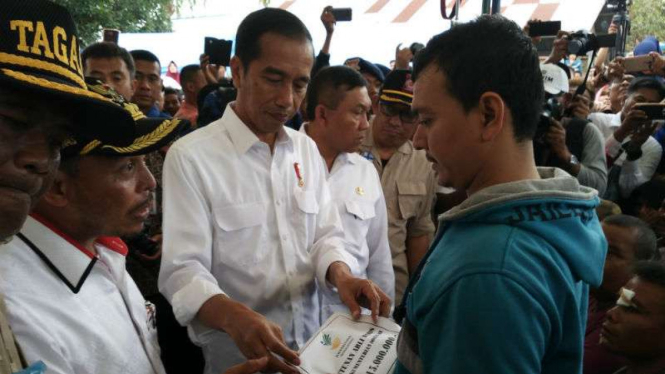 Presiden Jokowi menyerahkan bantuan kepada keluarga korban meninggal gempa Aceh
