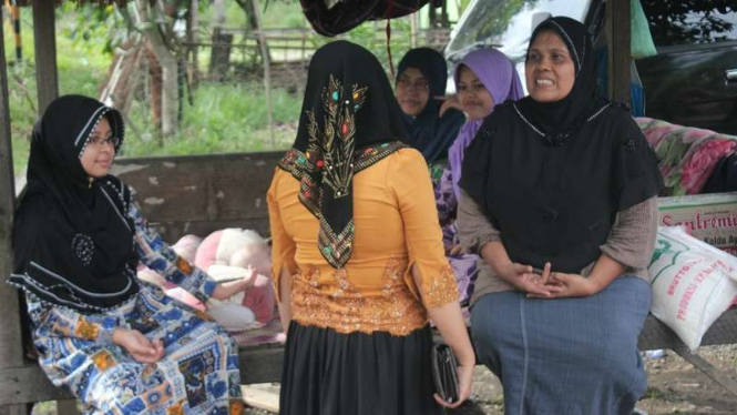 Sabitah (kanan) bersama keluarganya menyaksikan dampak kerusakan gempa bumi di Pidie Jaya Aceh, Minggu (11/12/2016). Bagi warga di Pidie, gempa tahun ini lebih menakutkan dibanding tahun 2004.
