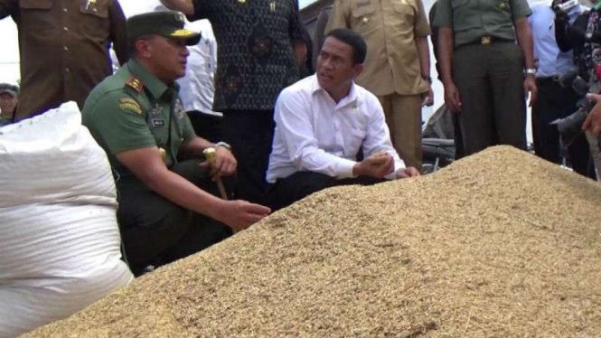 Menteri Pertanian, Andi Amran Sulaiman (duduk-kanan), dan Panglima Kodam Wirabuana, Mayor Jenderal TNI Agus Surya Bakti, dalam panen raya di Poso pada Selasa, 13 Desember 2016.