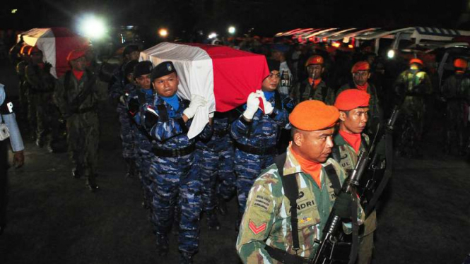 Prajurit TNI AU menggotong peti jenazah korban kecelakaan pesawat Hercules A-1334 untuk disemayamkan di Hanggar Skadron 32 Lanud Abdulrahman Saleh, Malang, Jawa Timur, Minggu malam, (18/12/2016)