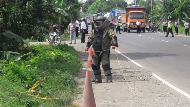 Petugas penjinak bahan peledak Polda Jawa Timur memeriksa sebuah benda yang awalnya dicurigai bom di Jalan Raya By Pass Mojokerto-Surabaya pada Kamis, 22 Desember 2016.