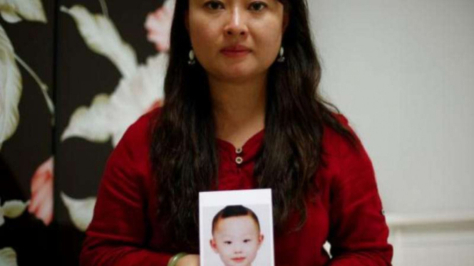Dai Xiaolei dengan foto anak laki-lakinya, Tristan.