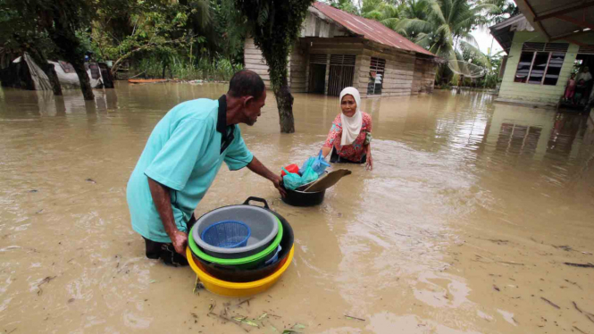 Warga di Aceh Utara memindahkan sejumlah barang rumah tangganya ketika rendaman bajir meninggi.