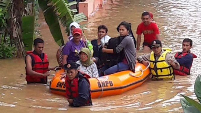 Petugas BPBD Kabupaten Solok mengevakuasi warga korban banjir dengan perahu karet pada Kamis, 5 Januari 2017.