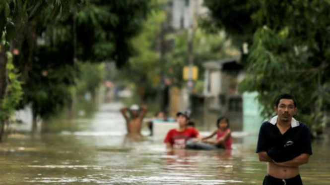 Penduduk Kota Nakhon di Provinsi Thammarat, Thailand, melalui jalan yang dilanda banjir.