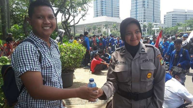 Polwan memberikan air mineral pada seorang mahasiswa peserta demonstrasi Aksi Bela Rakyat 121.