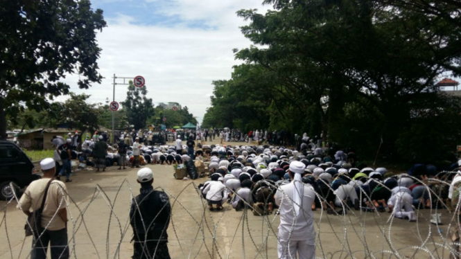 Massa FPI menunaikan salat di tengah jalan