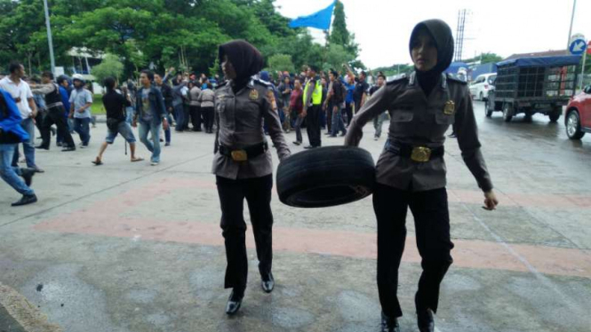Polwan merampas ban bekas dari mahasiswa yang berdemonstrasi di Jalan Urip Sumoharjo, Kota Makassar, Sulawesi Selatan, pada Kamis, 12 Januari 2017.