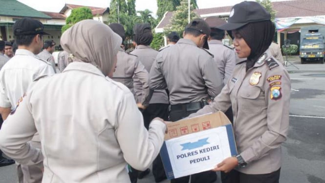 Polwan saat menyodorkan kardus Polres Kediri Peduli kepada anggota yang ikut apel dan anggota Babinkamtibmas saat menyerahkan bantuan sembako kepada warga tidak mampu.