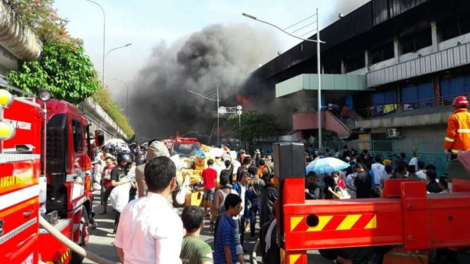 Petugas pemadam bahaya kebakaran dan para pedagang saat kejadian kebakaran di Pasar Senen Jakarta Pusat, Kamis (19/1/2017)