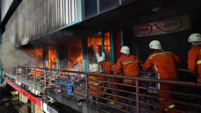 Petugas berusaha memadamkan api yang membakar kios di bangunan Blok I dan Blok II Pasar Senen di Jakarta, Kamis (19/1/2017).
