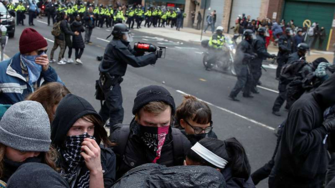 Polisi menembakkan gas airmata untuk membubarkan massa anti-Trump.