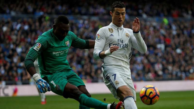 Pemain Real Madrid, Cristiano Ronaldo berduel dengan kiper Malaga