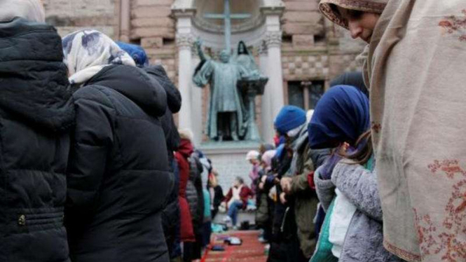 Perempuan Muslim sedang ibadah salat saat demonstrasi di Boston, AS.