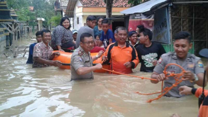 Petugas Polres Sampang bersama instansi terkait lain membantu evakuasi korban banjir yang stroke dengan perahu karet pada Kamis, 2 Februari 2017.