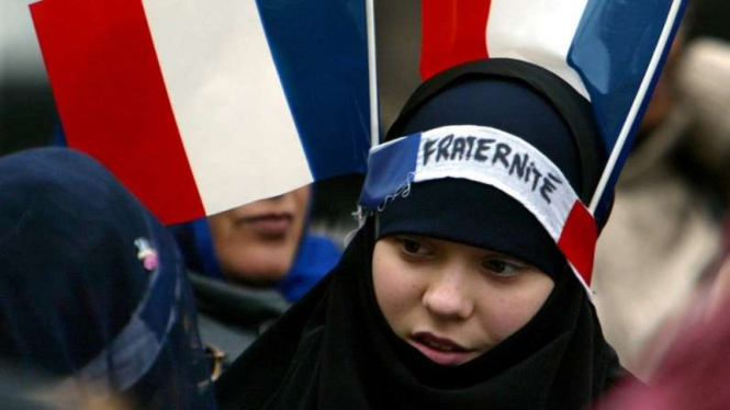 Perempuan Muslim dengan dua Bendera Prancis di Paris.