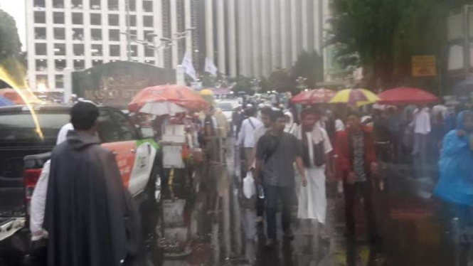 Saat massa peserta Aksi 112 bertahan di tengah guyuran hujan.