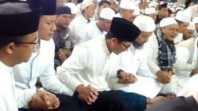 Anies Baswedan, Agus Harimurti Yudhoyono, dan Sandiaga Uno saling bergenggam tangan dalam aksi 112.