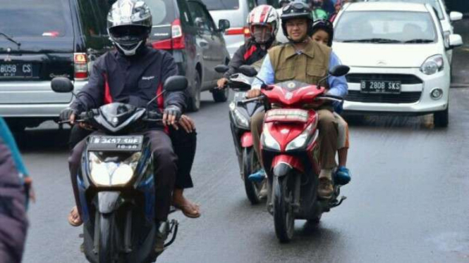 Anies Baswedan mengantar anak ke sekolah dengan motor, Senin, 13 Februari 2017.