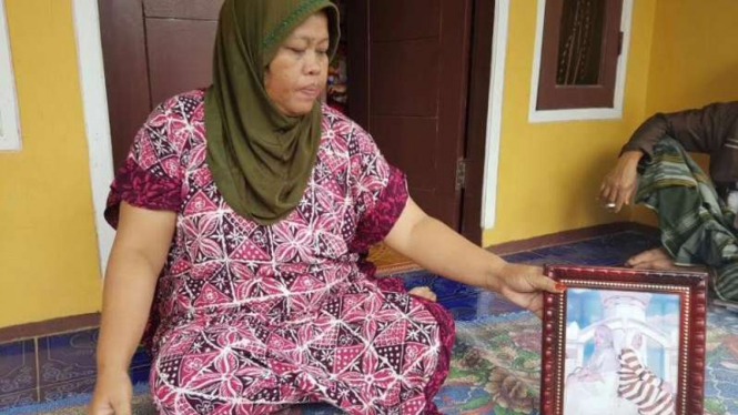 Ibunda Siti Aisyah, memperlihatkan foto anaknya.
