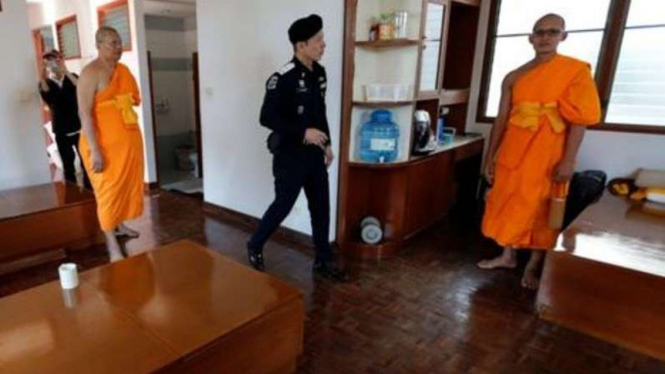 Seorang Polisi Thailand menggeledah Kuil Dhammakaya.
