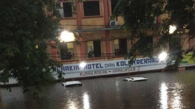 Kondisi ketinggian banjir di kawasan depan Hotel Al Hakim Bekasi yang merendam hingga atap mobil, Selasa (21/2017)