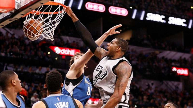 Aksi dunk power forward San Antonio Spurs, LaMarcus Aldridge (kostum abu-abu)