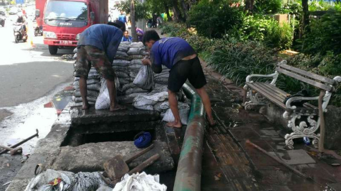 Pengangkutan sampah kulit kabel dari gorong-gorong Jalan Gatot Subroto, Jakarta.