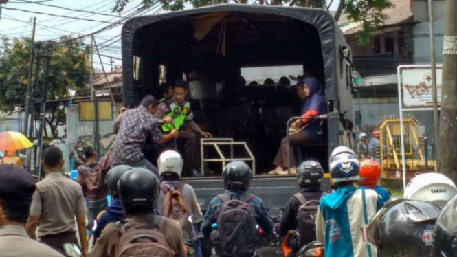 Warga penumpang transportasi umum diangkut truk polisi karena para sopir angkot berdemonstrasi di Kota Tangerang, Banten, pada Rabu, 8 Maret 2017.