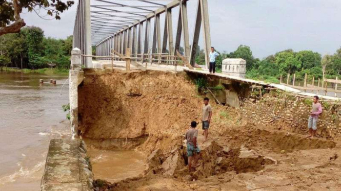 Sebuah jembatan yang sedang dibangun dan baru setengah jadi ambrol setelah diterjang banjir di Kabupaten Musi Rawas Utara, Sumatera Selatan, pada Rabu, 8 Maret 2017.