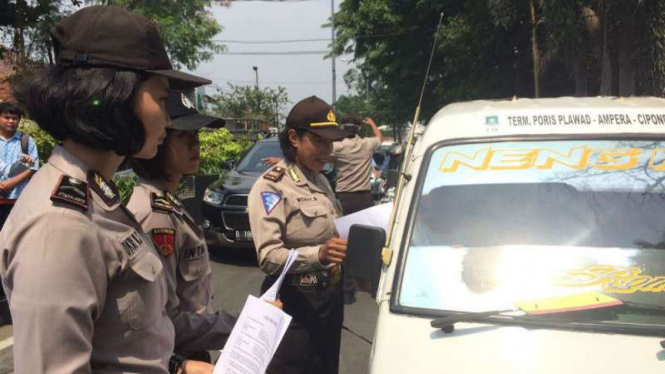 Polwan Polrestro Tangerang menyebarkan selebaran berisi kesepakatan perdamaian para sopir angkot dengan pengemudi angkutan berbasis aplikasi online pada Kamis, 9 Maret 2017.