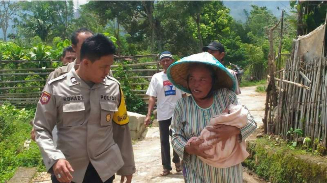 Dinarti, warga Desa Kota Agung Kabupaten Lahat, Sumatera Selatan menggendong bayi yang ditemukannya di perkebunan kopi, Sabtu (11/3/2017)
