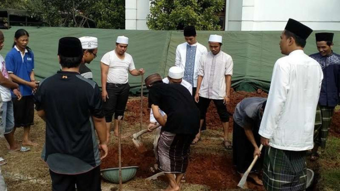 Santri Ponpes Al Hikam menggali liang lahat untuk jenazah KH Hasyim Muzadi.