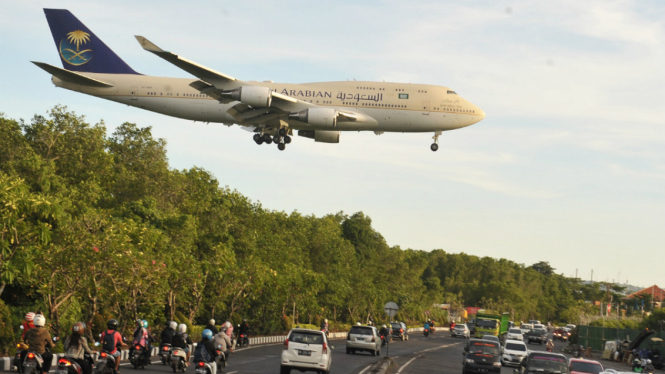  Pesawat Boeing 744 yang membawa Raja Arab Saudi Salman bin Abdulaziz Al Saud melintas di atas jalan sebelum mendarat di Bandara Internasional Ngurah Rai, Denpasar, Sabtu (4/3).