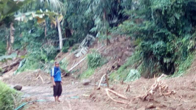 Warga menyaksikan lokasi tanah longsor di Cihanelem, Garut