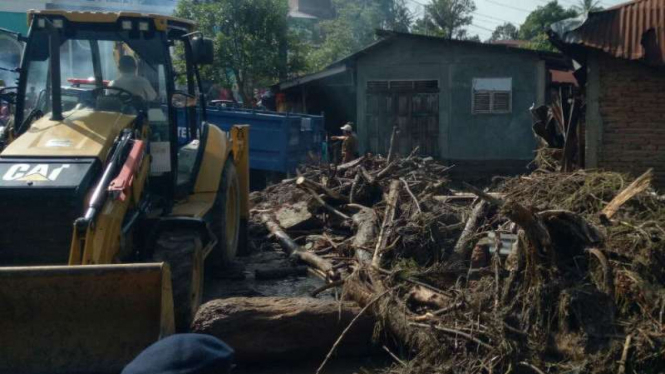 Aparat Polri dan BPBD membersihkan jalanan dan rumah-rumah warga yang terdampak banjir bandang di Kota Padang Sidempuan, Sumatera Utara, pada Senin, 27 Maret 2017.