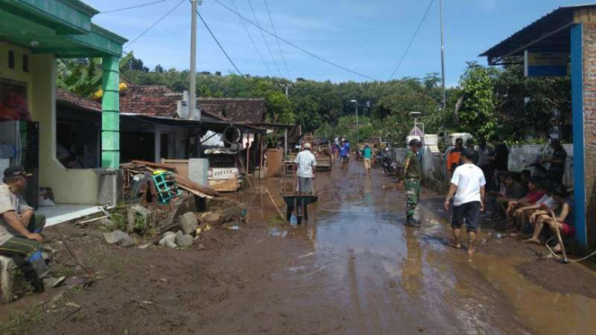 Petugas dan warga membersihkan lumpur di rumah-rumah akibat banjir bandang di Desa Kalikatir, Godang, Kabupaten Mojokerto, pada Senin, 27 Maret 2017.