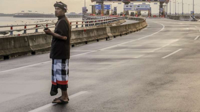 Seorang pecalang di Bali berjaga di jalan tol pada Hari Raya Nyepi.