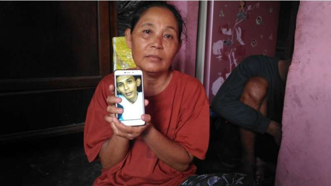 Ratni menunjukkan foto anaknya, Jumaidi Kasirin (34). Jumaidi pada tahun 2014 dilaporkan ditangkap di China atas penyelundupan narkoba.