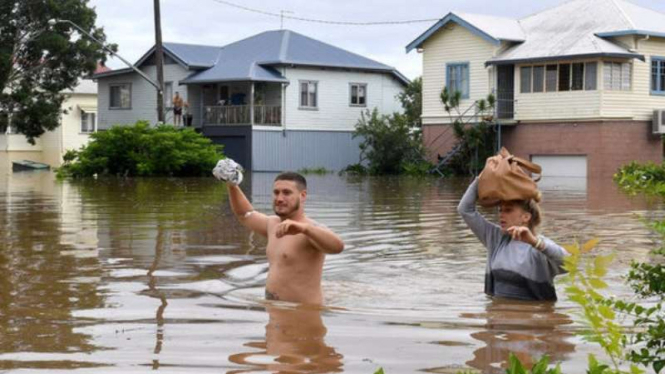 Warga Australia menyeberangi banjir yang menerjang wilayah mereka.