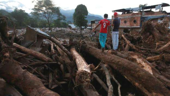 Sejumlah batang kayu terbawa arus sungai saat longsor di Kolombia.