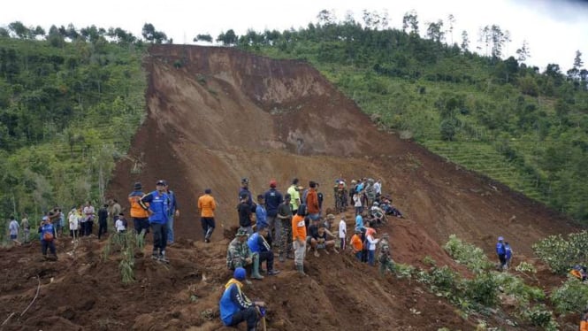 Warga melihat proses pencarian korban hilang tertimbun longsor di Desa Banaran, Ponorogo, Jawa Timur, Minggu (2/4/2017).
